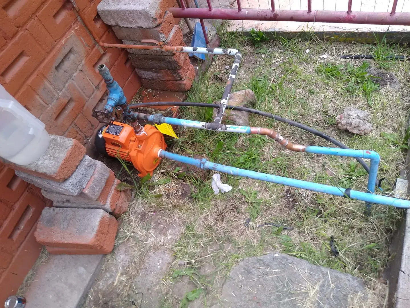 Plomero trabajando con equipo bomba de agua exterior